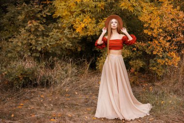 Yaprak döken arka planda güzel sonbahar kıyafetleri giymiş bir kadın. Sonbahar modası ve havası. Metin için boş alan