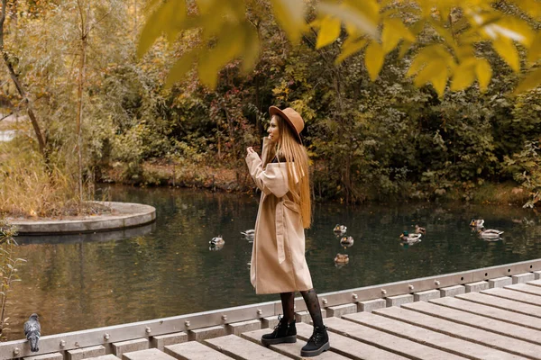 一个穿着秋装的女人在一个城市公园散步 — 图库照片