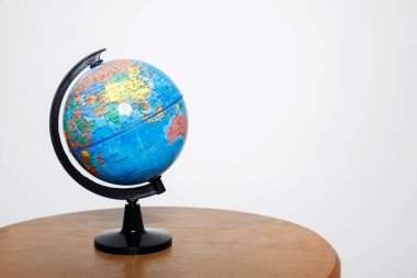 beyaz bir arka planda tahta bir masanın üzerindeki dünya