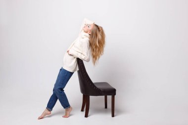 Gri arka planda kışlık giysileri olan parlak makyajlı çekici bir sarışın. blog yazarı