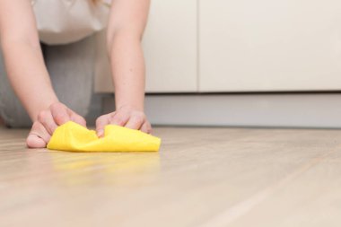 a woman washes the kitchen floor with a cleaning cloth. close-up