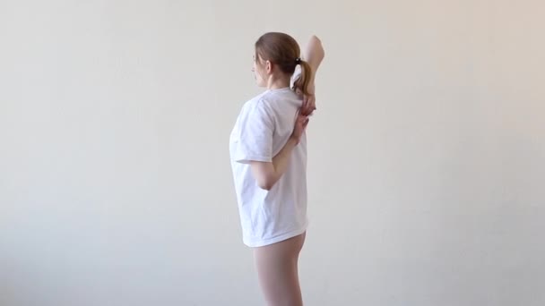 Girl Doing Exercises Her Back Charging Sports Plain Background — Stockvideo