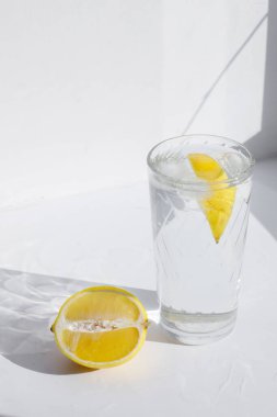 Hafif arka planda limonlu bir bardak su.