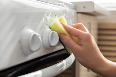 Mutfaktaki gaz sobasını deterjanlı bir süngerle yıka. Yakın plan. temizlik