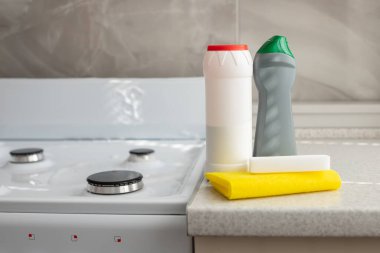 Mutfaktaki masada temizlik malzemeleri var. Plastik şişeler