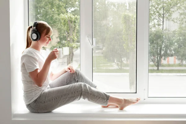 Een Vrouw Luistert Naar Muziek Drankjes Uit Een Kopje Het — Stockfoto