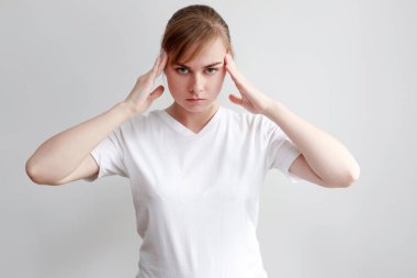 Beyaz arka planda başı ağrıyan bir kadın.