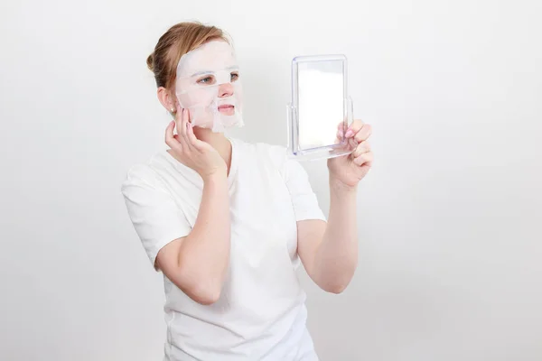 Una Mujer Una Máscara Tela Cosmética Con Espejo Sobre Fondo —  Fotos de Stock