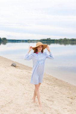 Sahilde hasır şapkalı bir kadın blogcu. yaz tatili