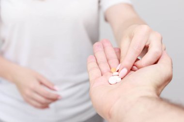 Bir kadın ellerinden hap alır. yakın plan