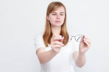 Bir kadın görüş için gözlük gösterir. Vizyon düzeltmesi. Kötü görme.