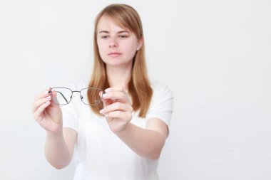 Kadın beyaz arka planda gözlük gösteriyor