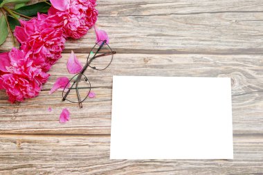 Ahşap bir arka planda gözlük, şakayık ve mocap.