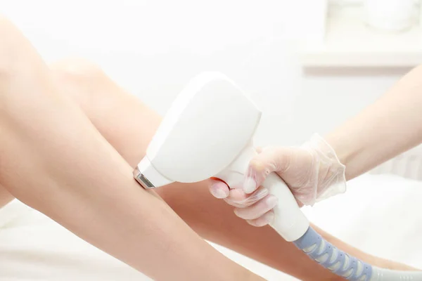 Diyot lazer çıkarımı, Güzellik Uzmanı güzel kadın bacaklarındaki kılları alıyor. Güzellik stüdyosunda ya da klinikte lazer tedavisi, vücut bakımı epilasyonu. Yumuşak cilt için saç kesimi.