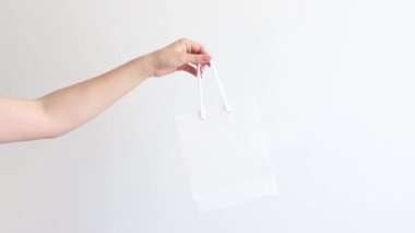 white craft bag in hand on white background