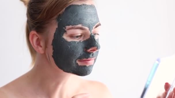 Woman Mask Clay Her Face Looks Mirror White Background — Vídeo de Stock