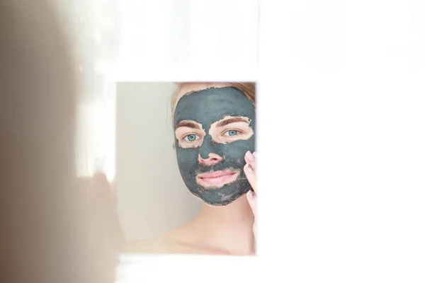 Portrait Smiling Woman Black Clay Cosmetic Mask Her Face Looks — Stock Photo, Image