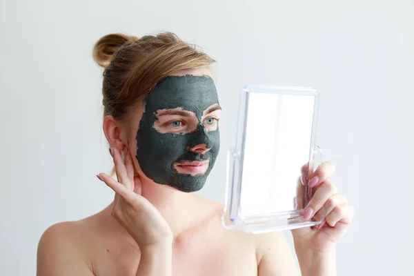 woman 30 years old in a cosmetic clay mask. home beauty treatments