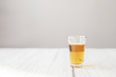 Tahta bir masada alkollü shot bardağı. alkolizm