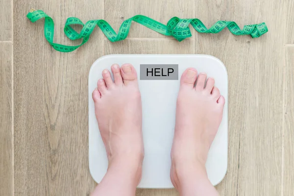 Kadın kendini zemin ölçeğinde tartıyor.