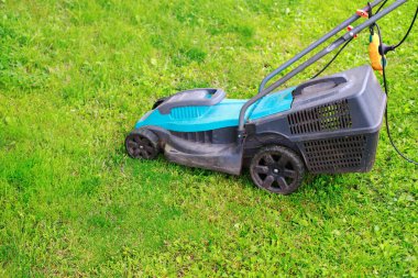 electric lawn mower on green lawn