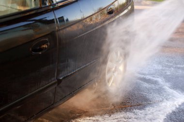 birisi bir araba yıkama yüksek basınçlı püskürtücü kullanarak bir carwash closeup