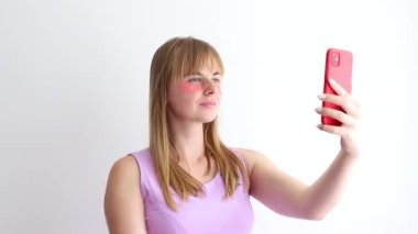 woman blogger in pink patches makes selfie on smartphone