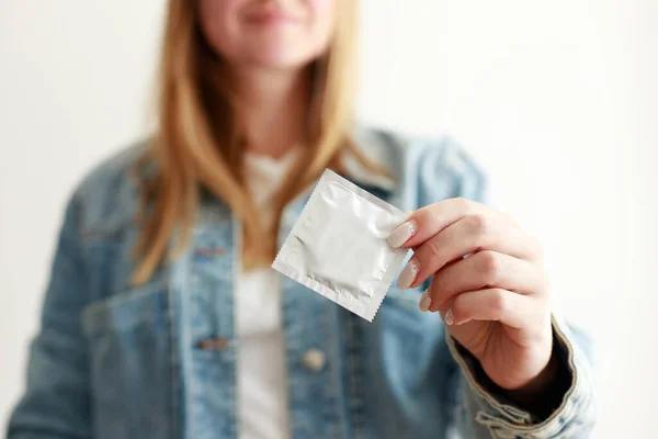 a woman gives a condom close-up. sex education