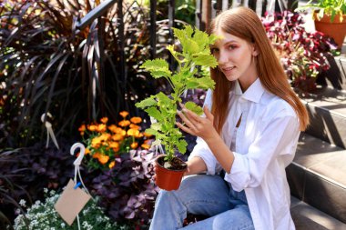woman with a flower in a pot at a flower market
