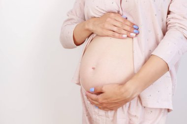 Pregnant expectant mother caressing her belly. Woman hands touching her tummy, waiting child, Girl big belly advanced pregnancy