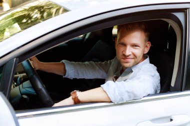 portrait of an attractive 30 year old man in a car