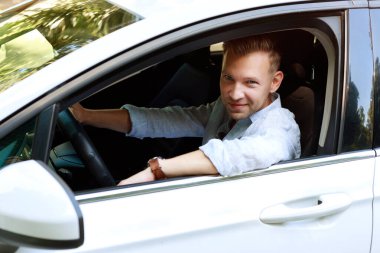 attractive man driving a car. rent a car, buy a car