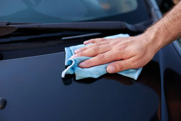 close-up man wiping the car after washing