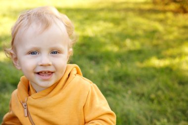 portrait of a little smiling baby on a walk in the park. place for text. banner