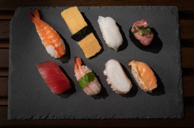 Japon suşisi (ton balığı, yumurta, karides, havyar, somon, ahtapot, mürekkep balığı) en az stilde tabakta.