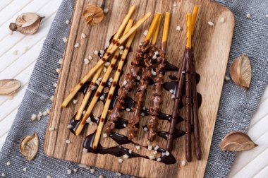 sweet chocolate stick on wooden plate with decorations.