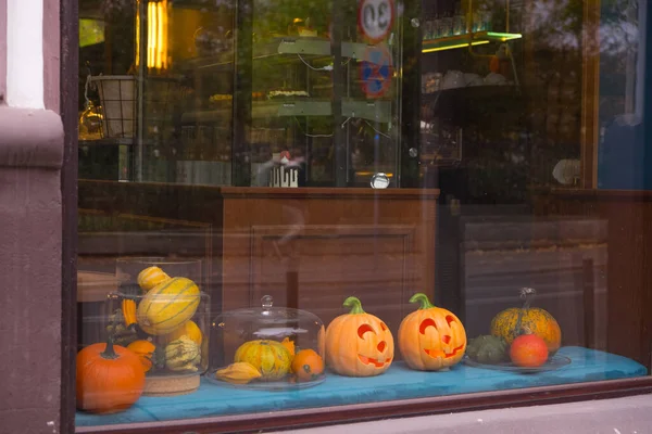 Autumn showcase, shop entrance decorated with flowers and pumpkin for halloween.