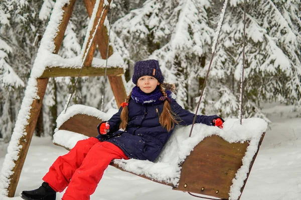 Κορίτσι Μπλε Σακάκι Κάθεται Μια Κούνια Ένα Χιονισμένο Δάσος — Φωτογραφία Αρχείου