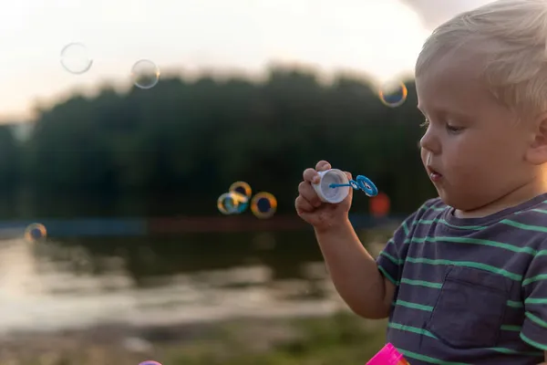 Kisfiú Szappanbuborékokat Fújt Tónál Parkban — Stock Fotó