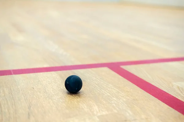 壁球位于分隔壁球区的两条线之间的木制地板上 — 图库照片