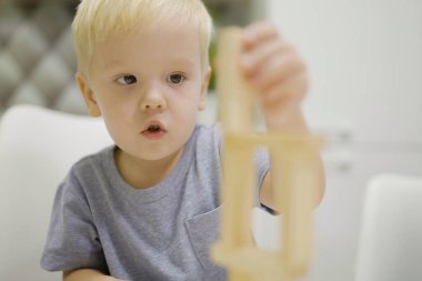 Küçük çocuk birlikte Jenga oynarken iyi eğlenceler. Tahta blokları ve çocukların eğlence konseptini kaldırmak için bir masa oyunu..