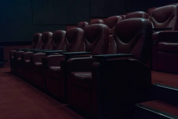 コロナウイルス検疫中に映画館の空の映画館で茶色の革の肘掛け椅子の列 — ストック写真