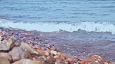 Background of water of pink color on which the waves are slowly moving.