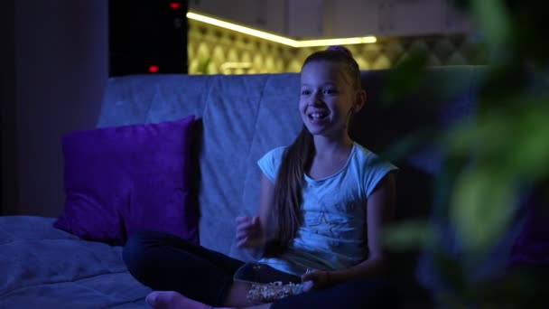 Έφηβος Κορίτσι Κάθεται Στον Καναπέ Βλέποντας Τηλεόραση Και Γελώντας — Αρχείο Βίντεο