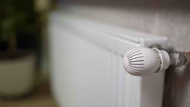 Tangan perempuan membuka katup pada radiator baterai untuk melarikan diri dingin di rumah — Stok Video