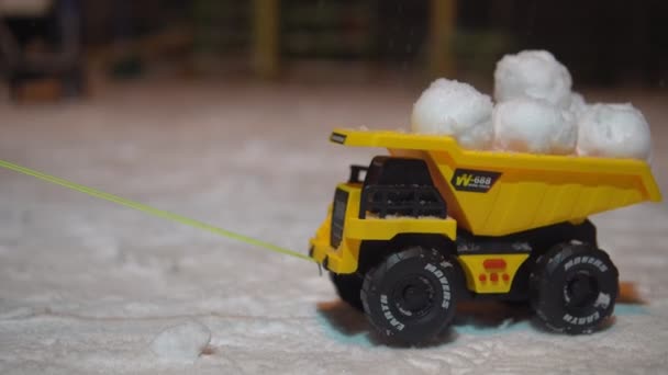 夜间雪地里装有雪球的玩具卡车 — 图库视频影像