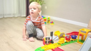 toddler plays with the children's railroad. Turns on green traffic light