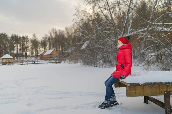 Blonde Woman Red Jacket Sit Wooden Pier Snow Covered Lake — Foto Stock