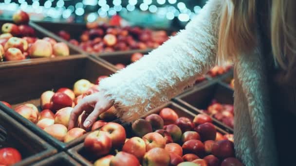 Vrouwelijke handen nemen appels uit houten dozen in supermarkt — Stockvideo