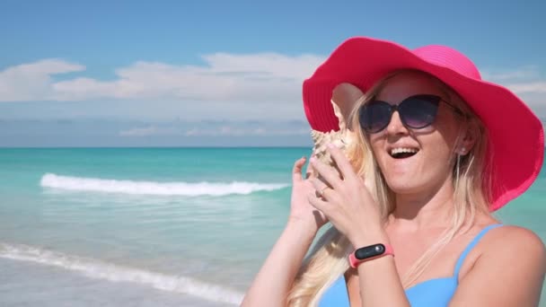 Flicka Havets Strand Rosa Hatt Lyssnar Skalet Och Förvånad Glad — Stockvideo